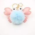 Détail d'un porte-clés crabe en peluche bleu clair avec pinces roses et mousqueton doré - Bleu clair
