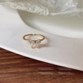 Dettaglio di un anello a fiocco dorato con zirconi e una fascia regolabile rifinita - Colore Oro 930 / Aperto Regolabile / Oro