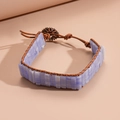 Detailansicht des geflochtenen Lederarmbands mit hellblauen Natursteinen und Blumenverschluss - Hellblauer Strukturierter Steinstil / Blau