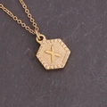 Detailed macro view of a gold hexagonal pendant featuring the embossed letter X on a chain - Letter X (24#X)