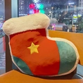 Macro view of Christmas stocking plush pillow with star embroidery on leather chair - Christmas Sock