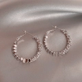 Orecchini a cerchio in oro rosa con micro-strass su sfondo di raso elegante - Stile Cerchio / Argento
