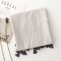 Detail shot of the soft cotton-linen fabric texture and elegant fringe on the scarf - Khaki Gray