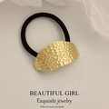 Minimalist black elastic hair tie featuring a hammered gold metal texture plate - Irregular Oval Embossed Pattern Gold
