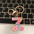 Letter Z resin keychain with heart sequins and rose gold hardware on a keyboard - Letter Z