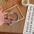 Detail of grey-green glazed glass bracelet with smooth texture in a Zen style setting - Grey Smudge Marble