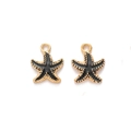 Macro shot of two black and gold starfish charms with enamel finish on white background - Black