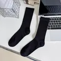 Minimalist black ribbed cotton mid-calf socks for women in clean office setting - Knee High / Black