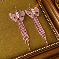 Detailed shot of vintage pink zircon butterfly tassel earrings on a velvet background - Earring Hooks / Pink
