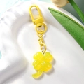 Primer plano de un llavero de trébol amarillo en un plato blanco con forma de corazón - Amarillo