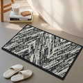 Absorbent chenille bath mat featuring a modern black and white abstract textured design - Prism Interwoven