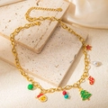 Golden stainless steel Christmas necklace featuring festive enamel charms on stone surface - Christmas Tree Gold Necklace
