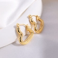 Detail polierter goldener Herz-Creolen mit Wellenform auf elegantem Seidenhintergrund - Gold Herz Creolen