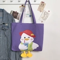 Detail of purple canvas tote with cartoon duck print and 3D plush feet decoration - Purple