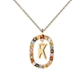 Macro shot of gold necklace pendant with colorful zircon stones and central letter K - Letter K
