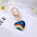 Golden heart keychain with rainbow enamel and rhinestone on a minimalist background - Blue Heart Rainbow