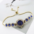 Detailed macro of gold quartz bracelet watch with blue dial and adjustable closure - Gold Blue