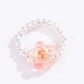 Close-up of bohemian beaded ring featuring white pearls and a pink floral glass bead - Iridescent Pink Orange Flower