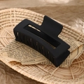 Matte black rectangular hollow hair claw clip displayed on vintage newspaper background - 8.5cm Black