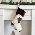 Detail of plush cow print Christmas stocking hanging on a white festive fireplace mantle - 20 inch / Brown Trim Cow Print