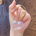 Handheld view of transparent cat-shaped capsule charm with golden wire keychain - Classic Pendant - Common Cat