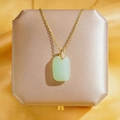 Collier doré élégant avec pendentif en jade vert sur un fond de satin couleur champagne - Collier Ruyi Vert