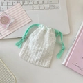 Detailed view of a white polka dot cotton linen drawstring bag on a macaron desk set - Fruit Green Rope