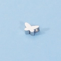 Macro shot of mirror-polished stainless steel butterfly charm with small hole for DIY jewelry - Steel