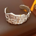 Detailed macro view of silver open cuff bracelet with irregular liquid metal texture - Silver