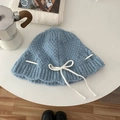 Light blue knit beanie with a white decorative bow knot flat lay on a white table - Hat / Blue
