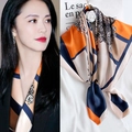 Silk scarf with geometric floral patterns in orange and blue shown on model and flat lay - Lucky Embroidery