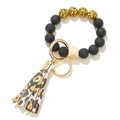 Detail of beaded keychain bracelet with matte black beads and leopard print leather tassel - Black Orange Leopard