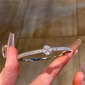 Detalle de pulsera de trébol plateada con pavé de circonitas cúbicas brillantes - Cuff Bracelet / Plateado