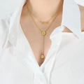 Collar de doble capa en titanio dorado con colgante Time y moneda en una modelo - Dorado