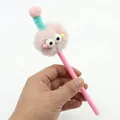 Detailopname van een creatieve roze pluche monsterpen met pluizige ogen en een groene spiraal - Roze