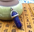 Detailed view of hexagonal lapis lazuli stone pendant with silver metal bail on bamboo background - Lapis Lazuli