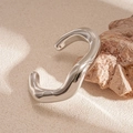 Dettaglio macro del bracciale in argento lucido con forme irregolari e stile metallo liquido - Argento