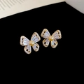 Detalle de pendientes de mariposa con circonitas y perlas en tono dorado claro - Dorado (Aguja de Plata S925)