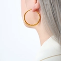 Golden thick twist hoop earrings in a minimalist retro style worn by a model - Large Spiral Style (F881)