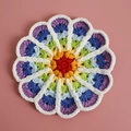 Handmade crochet round rainbow coaster with colorful petals and white chenille trim - Rainbow Gradient