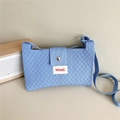 Detailed shot of blue knitted phone bag with diamond texture and metal magnetic closure - Blue