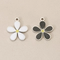 Detailed macro shot of 18K gold plated flower charms with white and black enamel petals - Silver