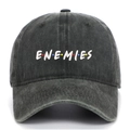 Close-up of white ENEMIES embroidery on washed denim baseball cap with colored dots - Army Green