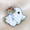 Close-up of white enamel ghost brooch with sparkling rhinestones on beige silk background - Ghost with Bouquet / White