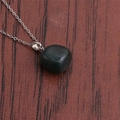 Macro detail of natural green aventurine stone pendant on a silver link chain necklace - Dark Green Stone