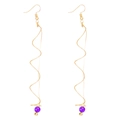 Detail of gold spiral wire earrings featuring purple pearl accents and drop design - Purple Bead Spiral Earrings / Purple