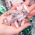 Gedetailleerde close-up van rozenkwarts zeshoekige hangers met zilveren metalen kapjes - Rozenkwarts