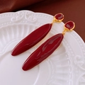 Elegant deep red enamel drop earrings with gold-tone hardware on white porcelain - Dark Red Long Oval Dangle