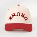Detailed view of the DRUNK embroidery on a red and beige color-block cotton baseball cap - Off-white Spliced Red