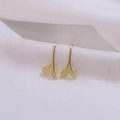 Macro view of gold leaf earrings showing delicate plant veins on white textured fabric - Gold